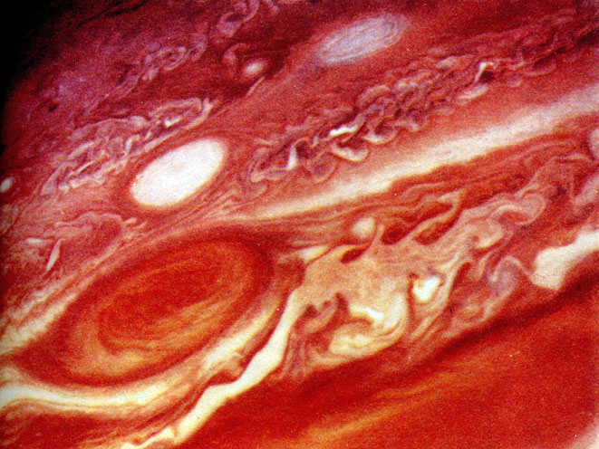 Фото 3. Большое Красное Пятно - долгоживущее образование в атмосфере Юпитера, окруженное турбулентной облачностью. (Фотография получена космической станцией 'Вояджер'; НАСА и Лаборатория реактивного движения.)