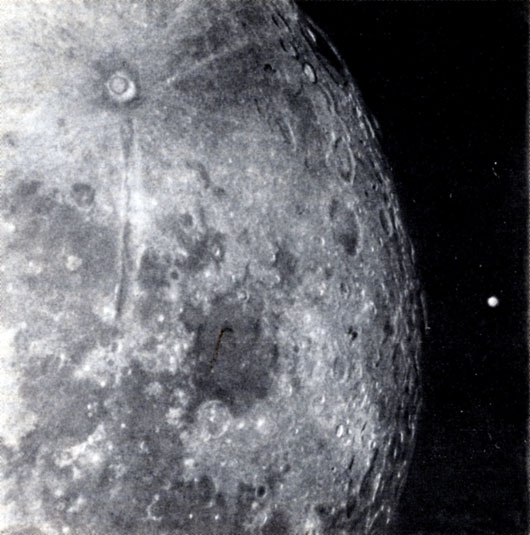 Рис. 8. Эта фотография, сделанная в 1911 г., объясняет, почему так трудно изучать Марс с Земли. Как здесь видно, Марс появляется из-за Луны над затемненной частью ее поверхности. Хотя в это время он был относительно близок к Земле, по своим размерам казался не больше самого маленького лунного кратера. (Фотография Ловелловской обсерватории.)